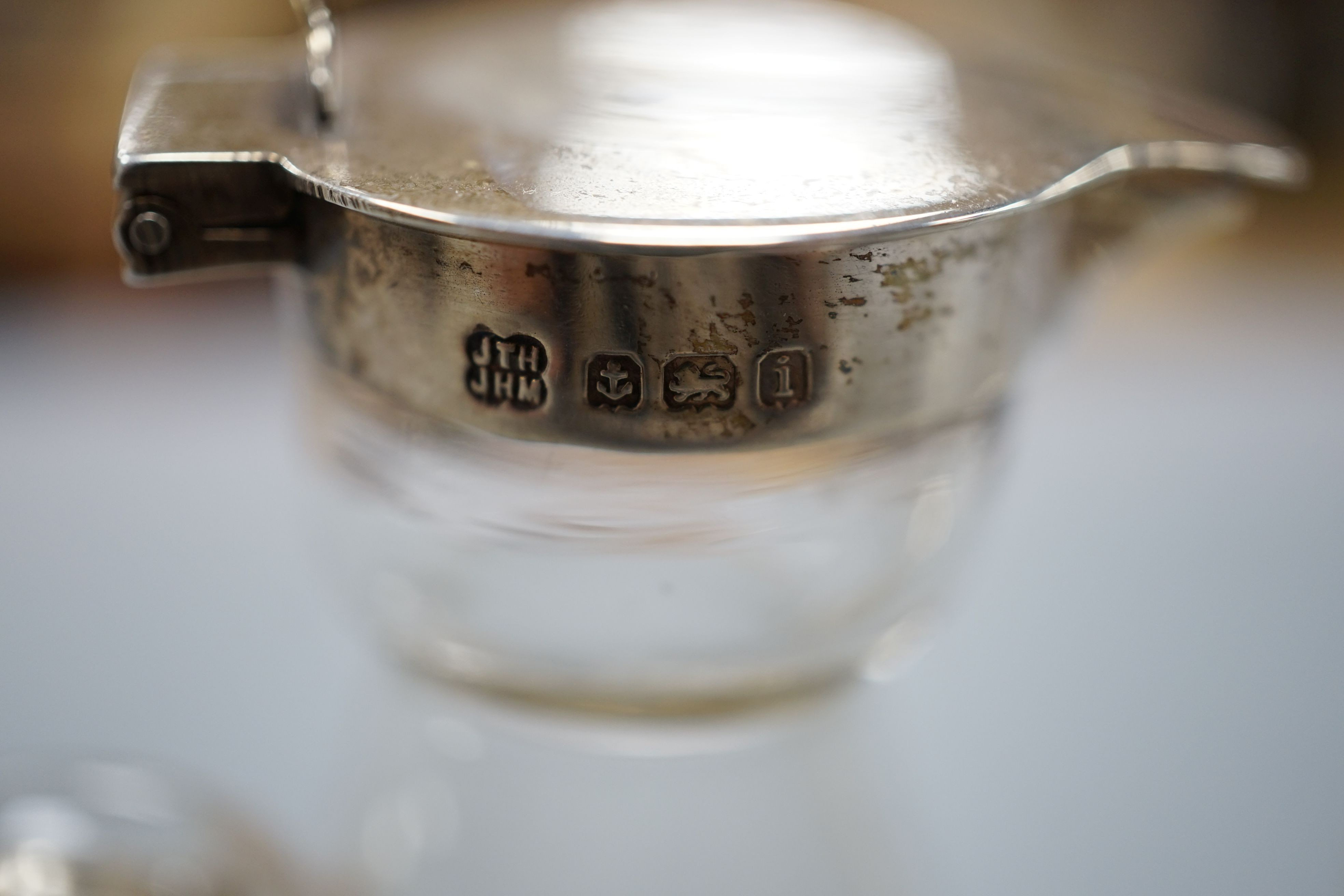 Five early 20th century and later silver mounted glass whisky tot jugs by Hukin & Heath, including a pair, Birmingham 1932, together with two silver Whiskey labels, 11cm.